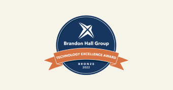 Brandon Hall Group Technology Excellence Award bronze seal 2022, round badge with navy background and orange ribbon