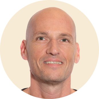 bald man smiling, close-up portrait with neutral background