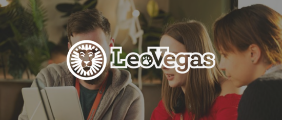 professional team discussing on a tablet at a modern workspace with plants, featuring the LeoVegas logo, team collaboration in stylish office setting