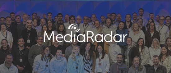 MediaRadar team group photo at event, showcasing diverse individuals in professional attire with branded event badges, MediaRadar event team gathering