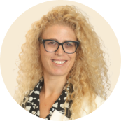 curly blonde woman with glasses smiling in a formal outfit, professional portrait with light background and circular frame