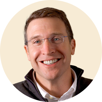 happy man with glasses smiling, portrait of a man in a round frame wearing a dark jacket