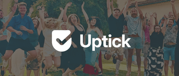 group of joyful people jumping outdoors, with the Uptick logo prominently displayed in the center, celebration, teamwork, outdoor fun