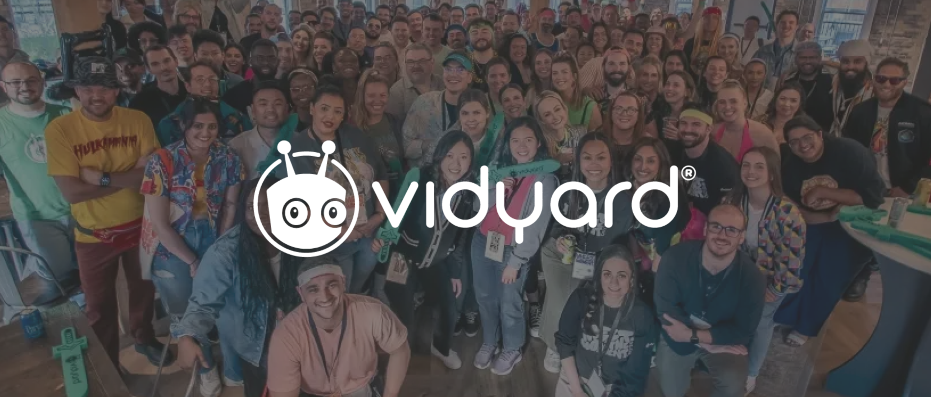 group photo of diverse Vidyard team members smiling at an event, showcasing vibrant attire and a lively atmosphere, Vidyard team event photo, diverse group of smiling individuals celebrating together
