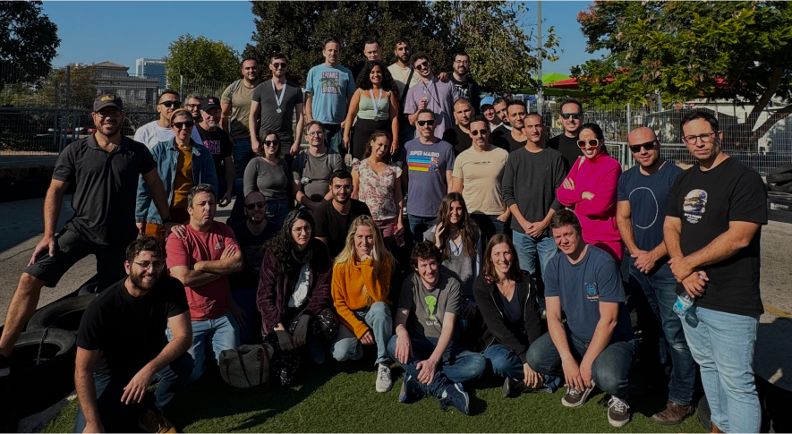 group photo of diverse people outdoors in casual attire, with greenery and urban backdrop, team gathering showcasing camaraderie and unity